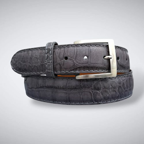 A dark gray alligator leather belt with a silver buckle, neatly coiled on a light gray background.